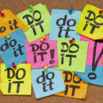 Post-it multicolores portant le message « do it » épinglés sur un tableau en liège