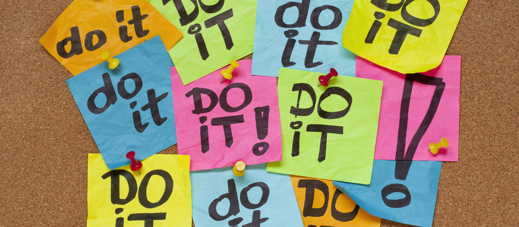 Post-it multicolores portant le message « do it » épinglés sur un tableau en liège