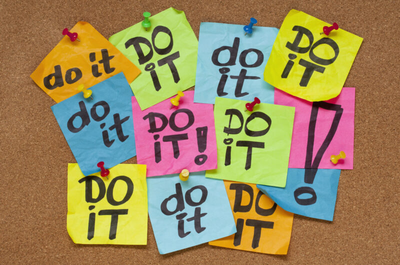Post-it multicolores portant le message « do it » épinglés sur un tableau en liège