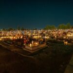 Cimetière illuminé de bougies à la tombée de la nuit le jour de la Toussaint