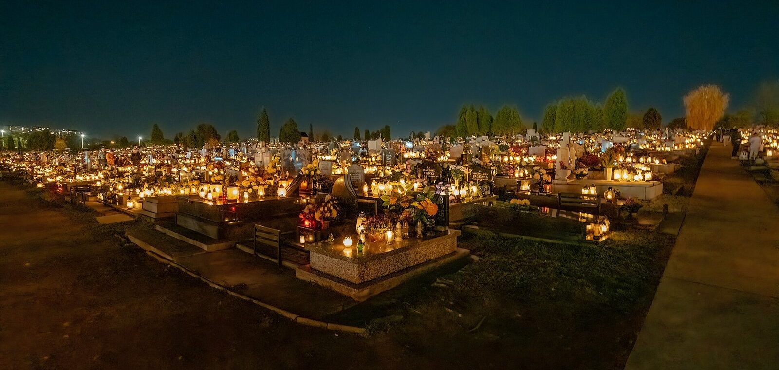 Cimetière illuminé de bougies à la tombée de la nuit le jour de la Toussaint