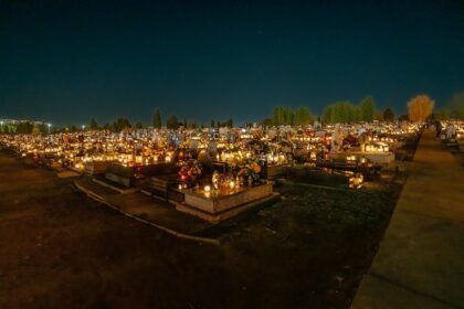 Cimetière illuminé de bougies à la tombée de la nuit le jour de la Toussaint
