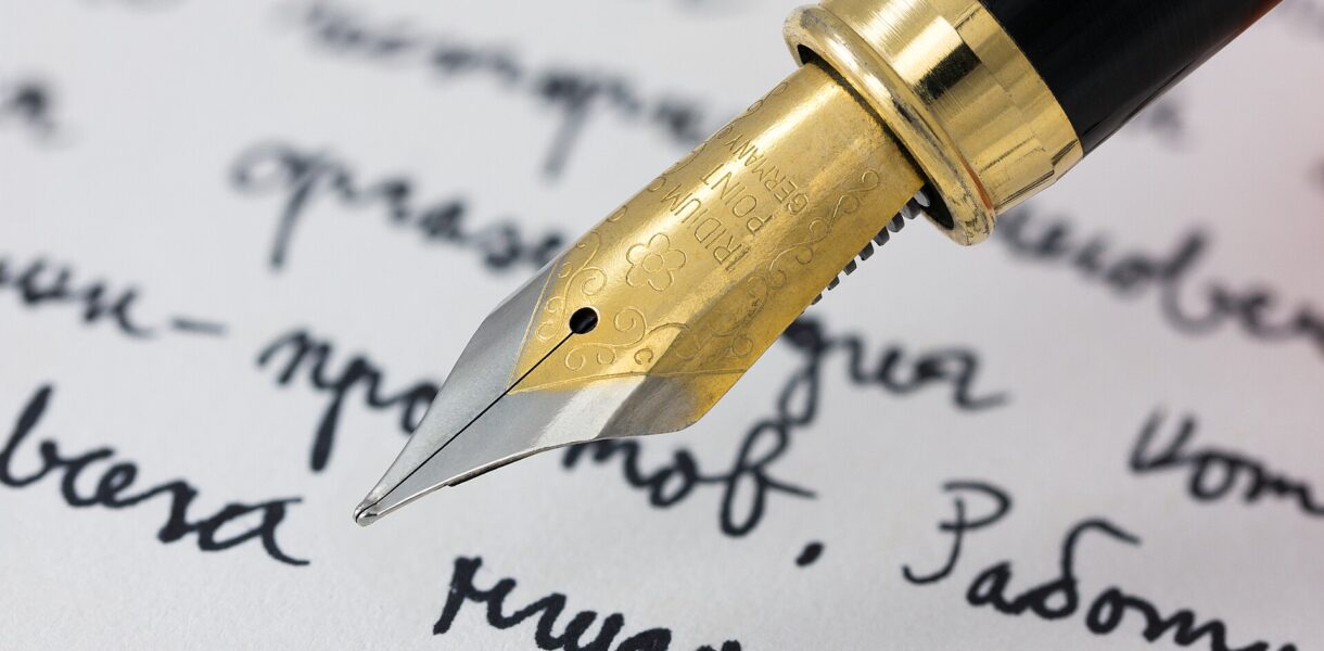 Stylo plume posé sur une page manuscrite