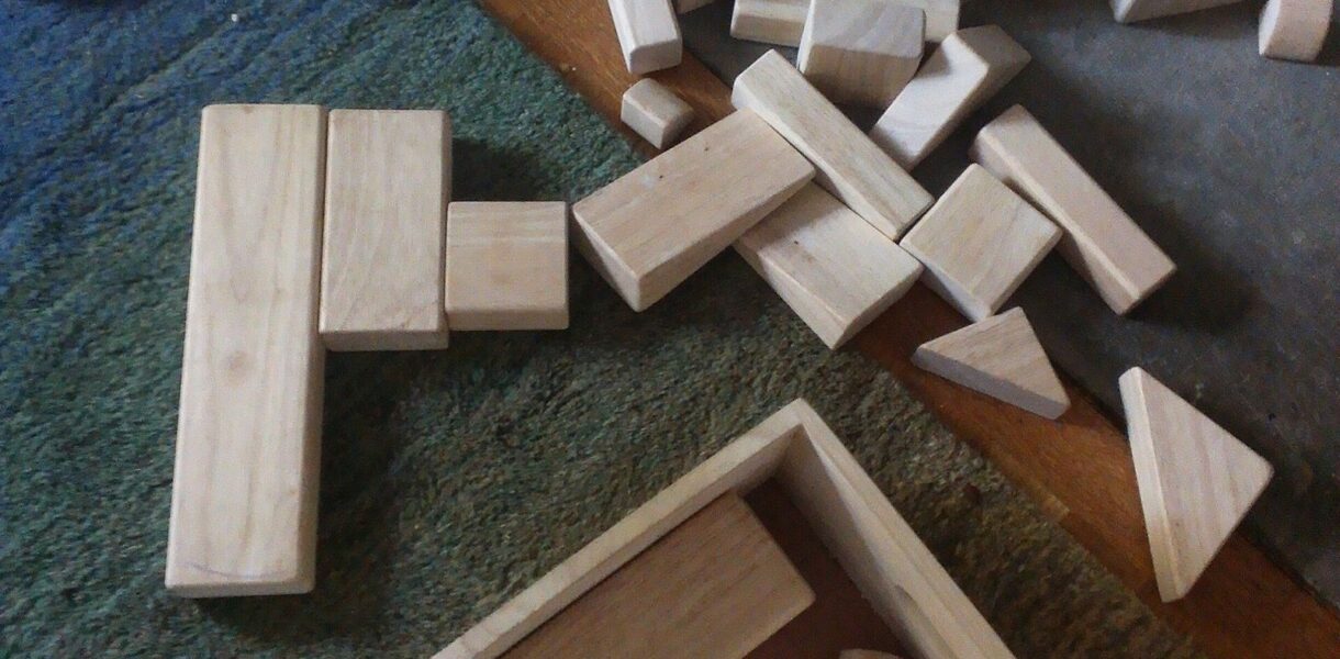 Jeux de construction en bois éparpillés sur un tapis
