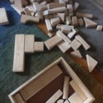Jeux de construction en bois éparpillés sur un tapis