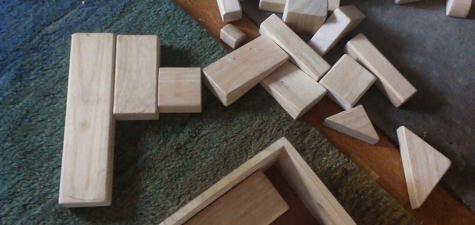 Jeux de construction en bois éparpillés sur un tapis