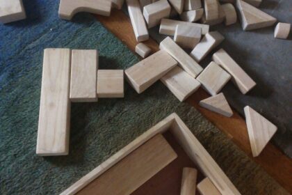 Jeux de construction en bois éparpillés sur un tapis