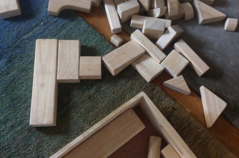 Jeux de construction en bois éparpillés sur un tapis