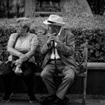 Deux personnes âgées en conversation sur un banc, photo en noir et blanc